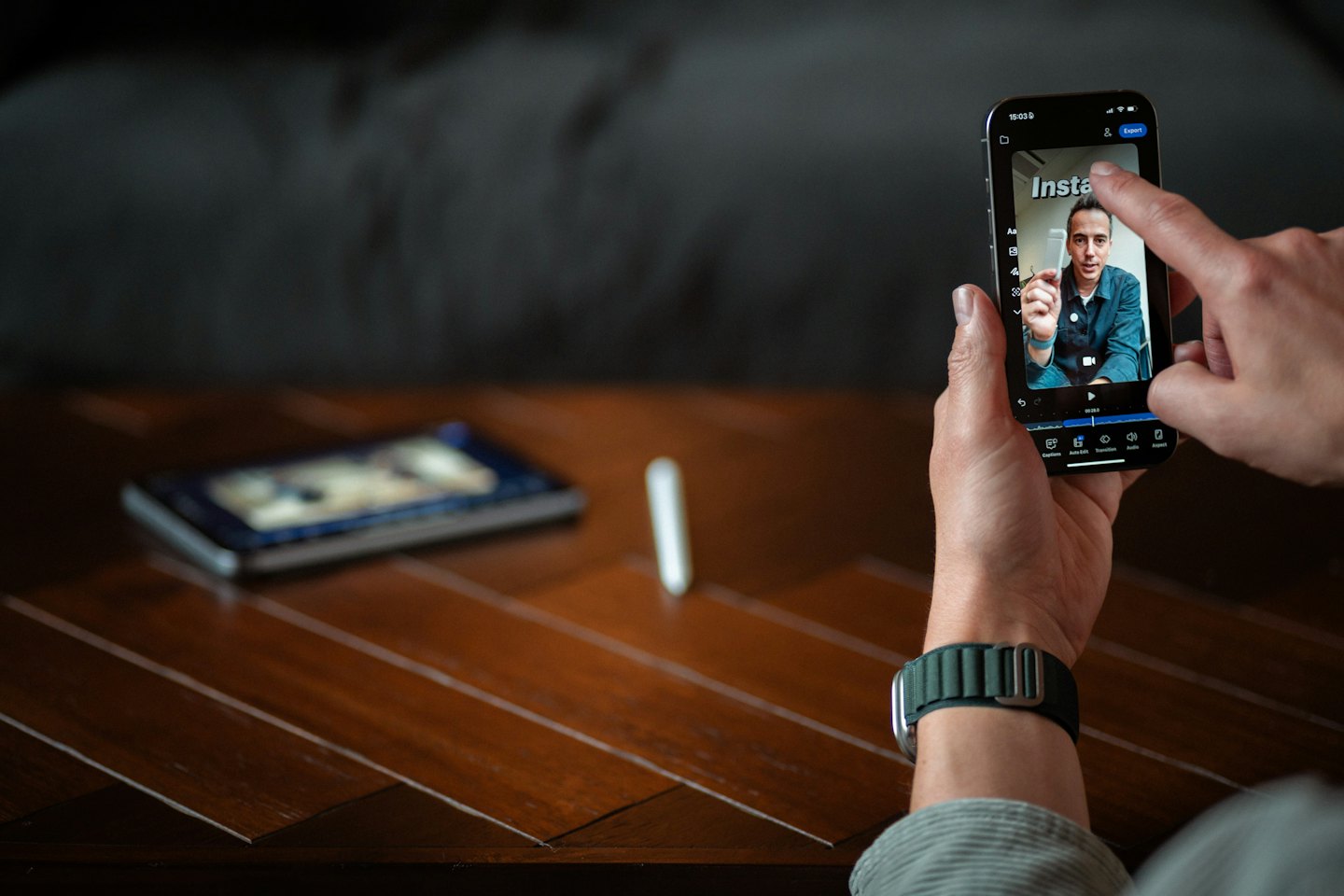 Hands edit a video on a smartphone touchscreen.