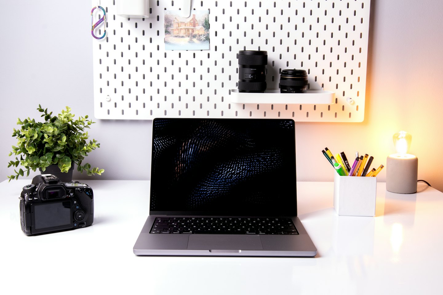 Laptop and office supplies on a clean white desk.